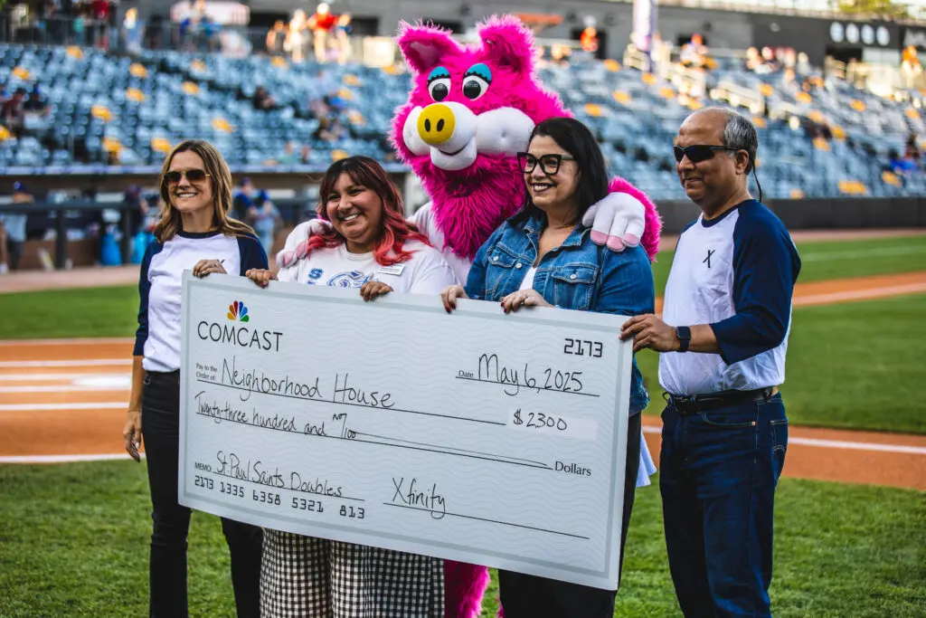 Four people standing holding a check